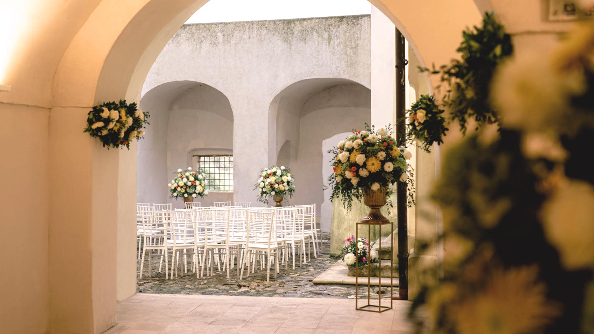 sedie bianche e addobbi floreali in una location per matrimoni civili a Caserta